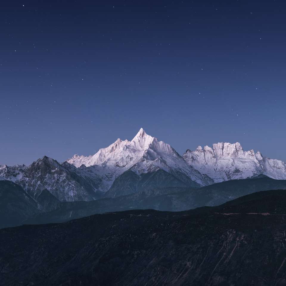 заснежена планина под синьо небе през деня плъзгащ се пъзел онлайн