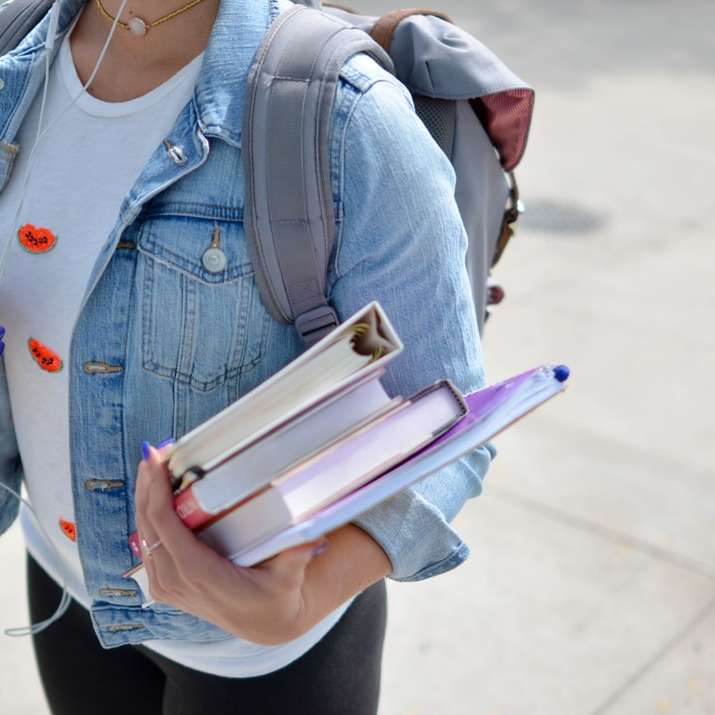 žena na sobě modrou džínovou bundu drží knihu online puzzle