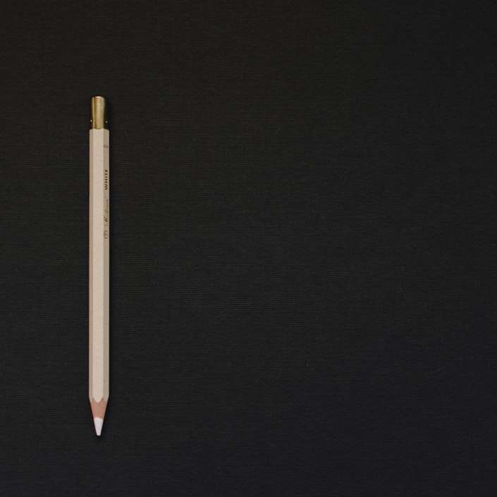 vit penna på svart plattform glidande pussel online