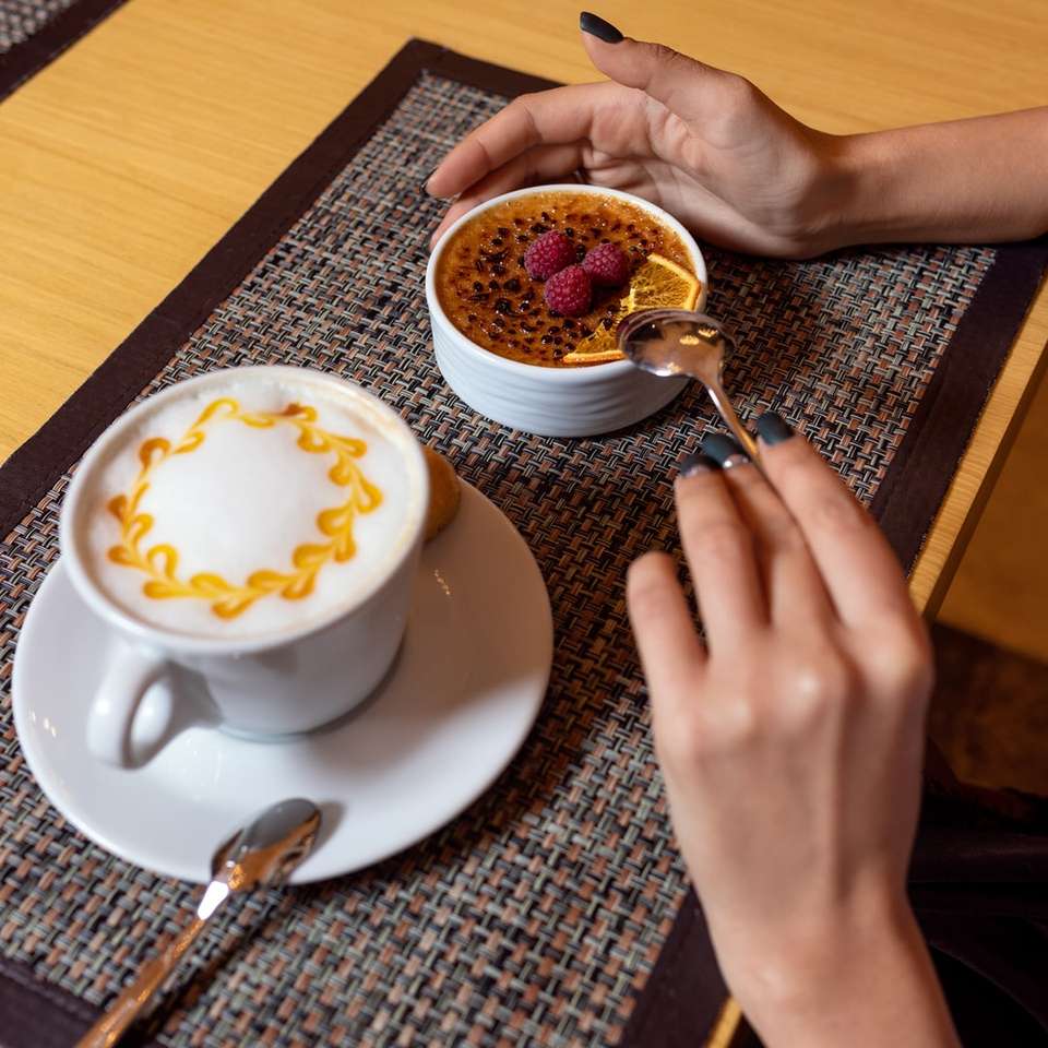 person holding white ceramic cup with saucer and spoon sliding puzzle online