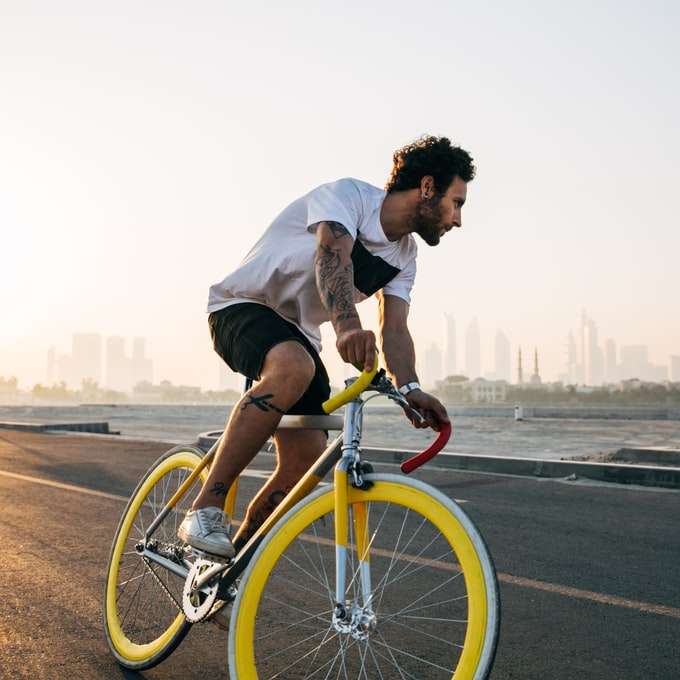 мъж, каращ велосипед по пътя през деня плъзгащ се пъзел онлайн