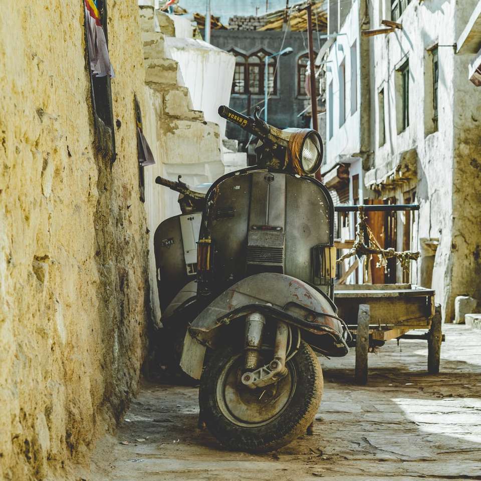 gray motor scooter parked beside brown wall online puzzle