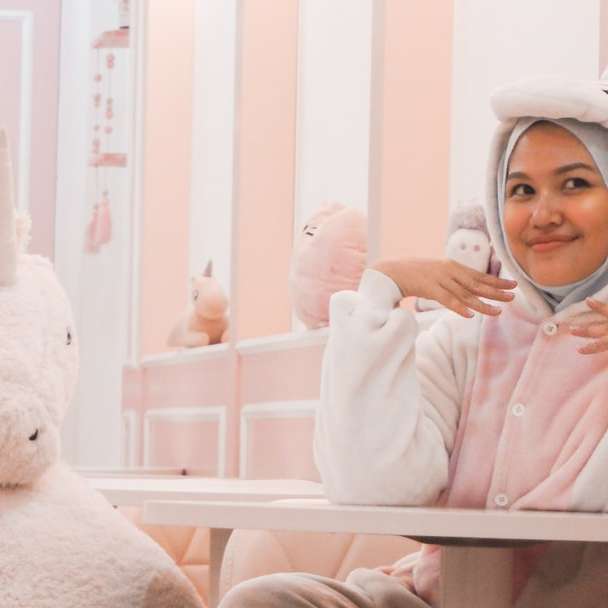 mujer vestida de blanco y rosa traje de unicornio silla sentada puzzle deslizante online