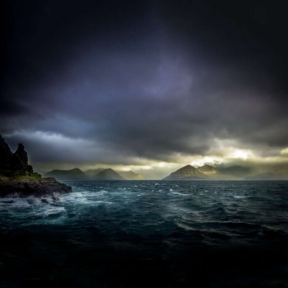 φωτογραφία τοπίου με νερά, βουνά και μαύρα σύννεφα online παζλ