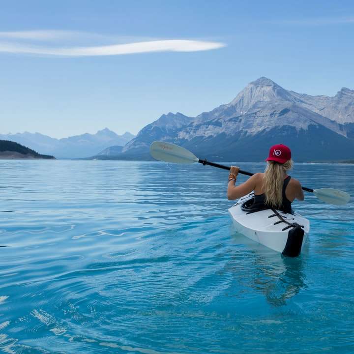femme portant un chapeau rouge à cheval sur un kayak blanc puzzle en ligne