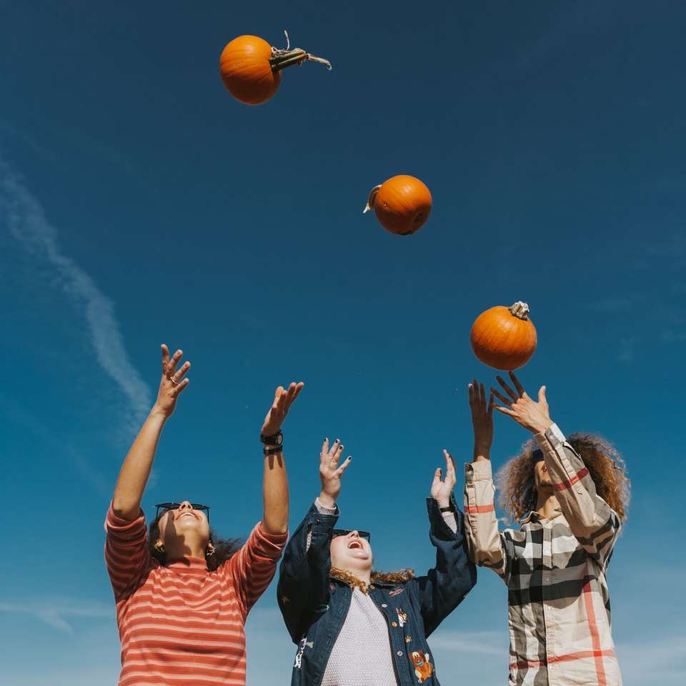 люди держат оранжевый баскетбол под голубым небом онлайн-пазл