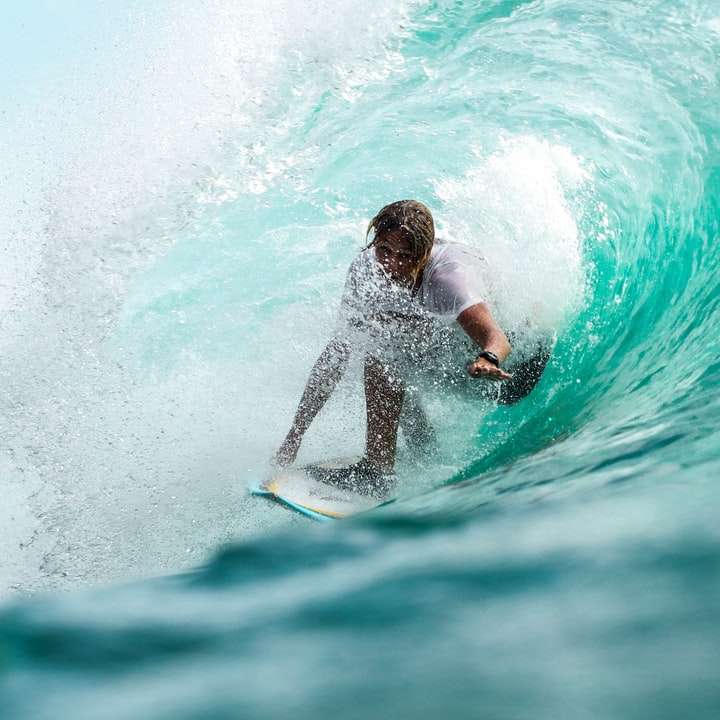 Сърфист за снимки във времеви интервали във вода с вълни плъзгащ се пъзел онлайн