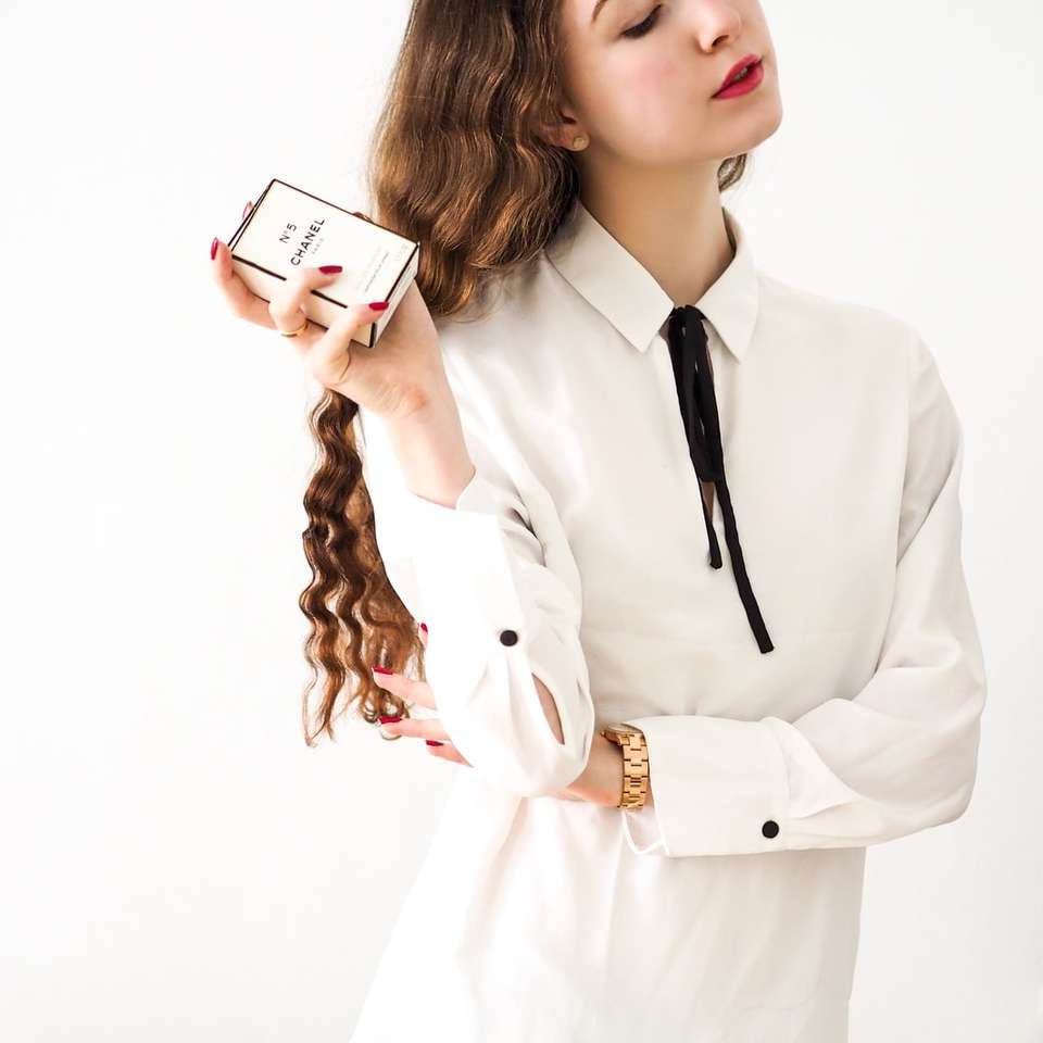 Frau im weißen Blazer mit weißem Smartphone Schiebepuzzle online