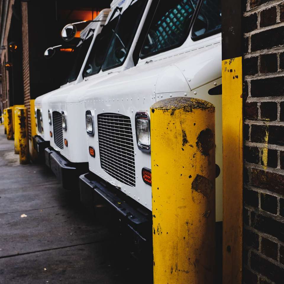 três veículos brancos estacionados na garagem puzzle deslizante online