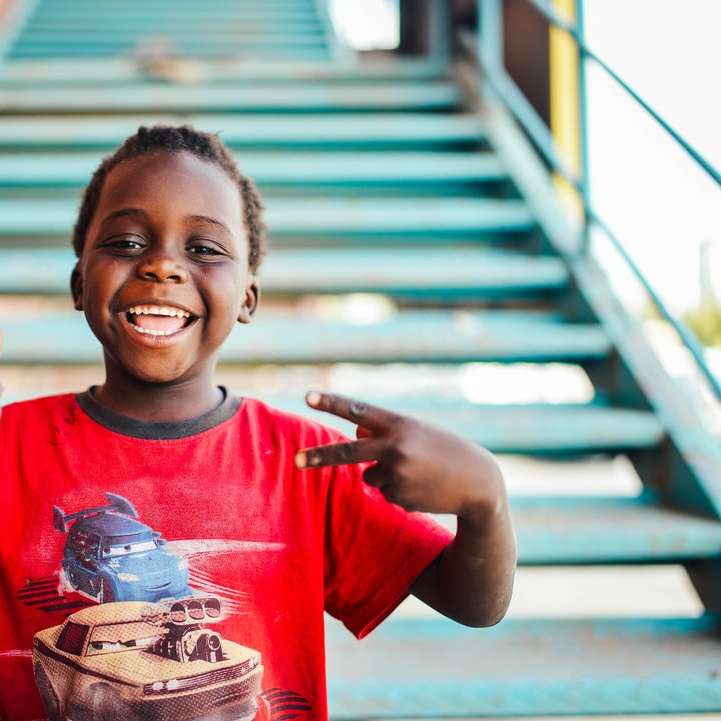 αγόρι που στέκεται κοντά σε σκάλες κάνει σημάδι ειρήνης τη μέρα συρόμενο παζλ online