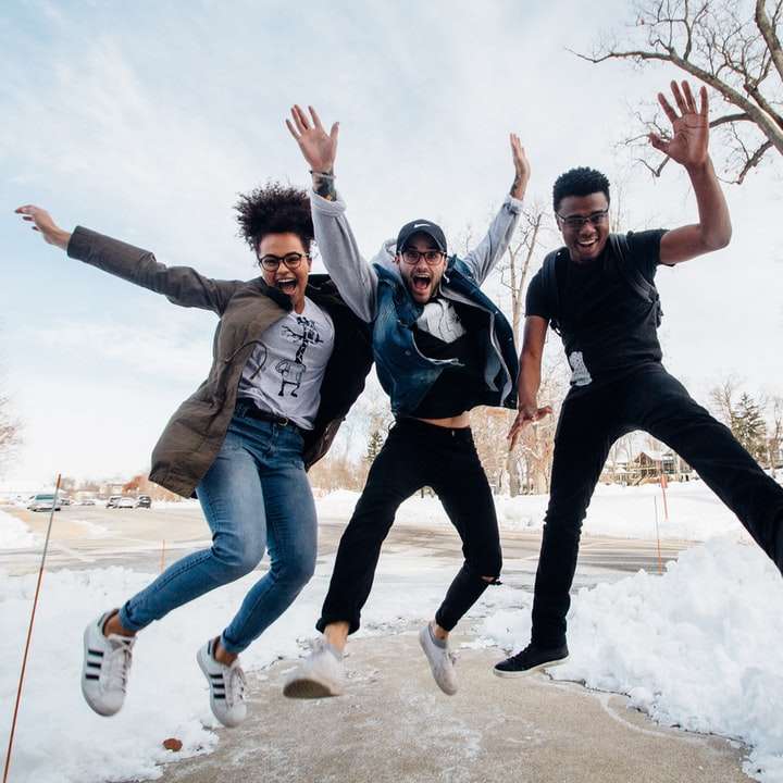 photo of three men jumping on ground near bare trees online puzzle