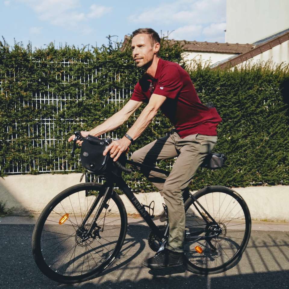 άνδρας με κόκκινο πουκάμισο πόλο ιππασία σε μαύρο ποδήλατο online παζλ