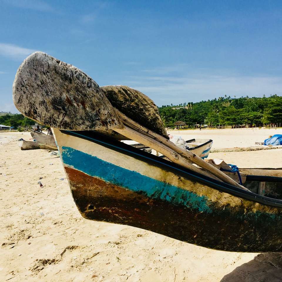 коричнево-синяя лодка на пляже в дневное время онлайн-пазл