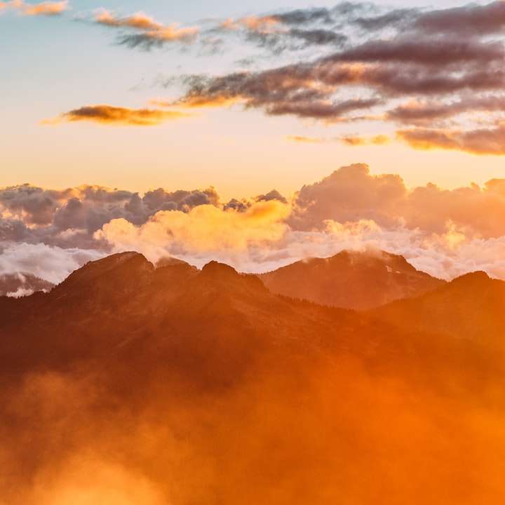 landskapsfotografering av berg med molnig himmel Pussel online