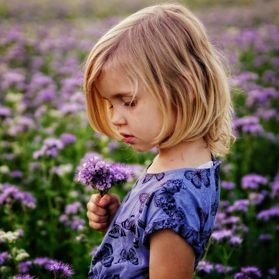niña sosteniendo flores moradas rompecabezas en línea
