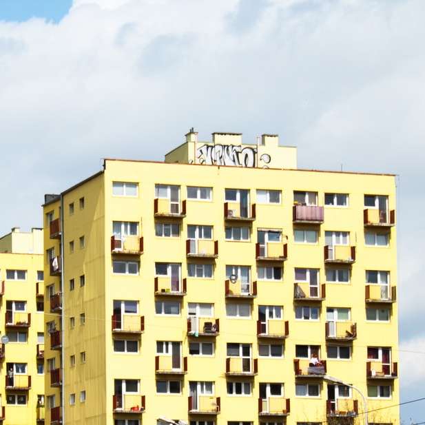 κίτρινο και καφέ σκυρόδεμα κτίριο κάτω από το γαλάζιο του ουρανού συρόμενο παζλ online