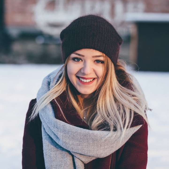 茶色のスカーフと栗色のコートを着て笑顔の女性 オンラインパズル