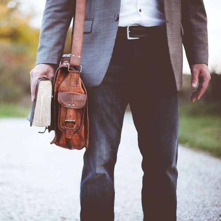 mężczyzna trzymający książkę na drodze w ciągu dnia puzzle przesuwne online