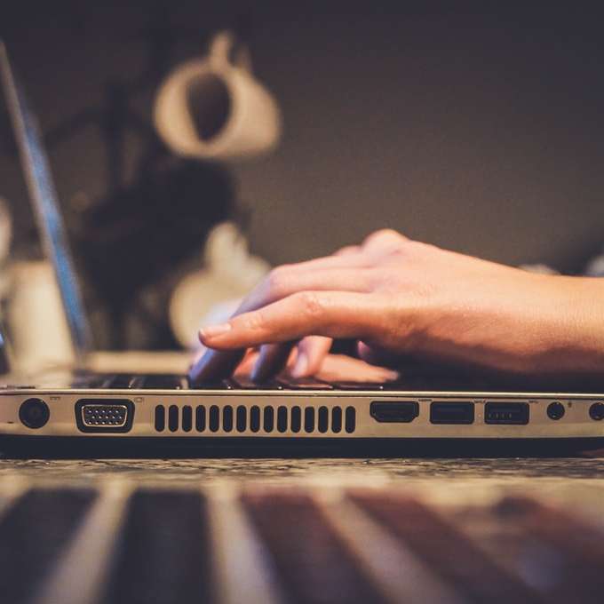 άτομο που χρησιμοποιεί ασημί φορητό υπολογιστή στο γραφείο συρόμενο παζλ online