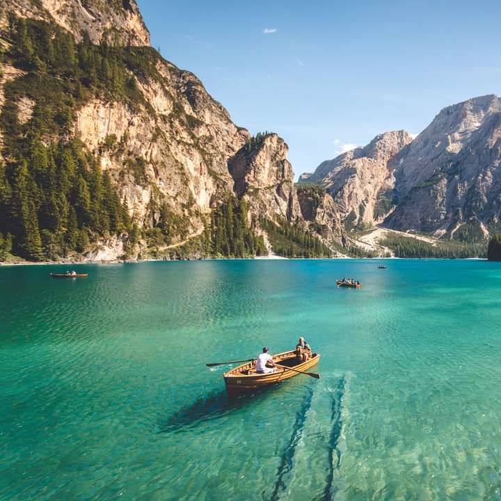 Tre brun träbåt på blå sjö vatten som tas på dagtid Pussel online