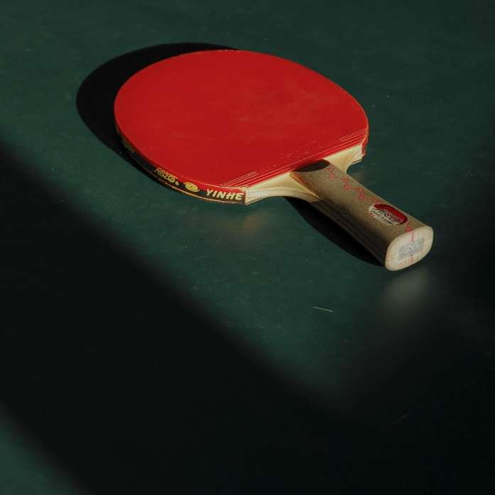 Mesa de ping pong roja y marrón sobre panel verde puzzle deslizante online