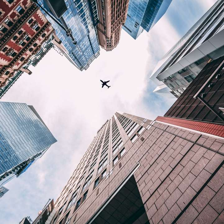 вид с высоты птичьего полета на самолет, летящий над городом онлайн-пазл