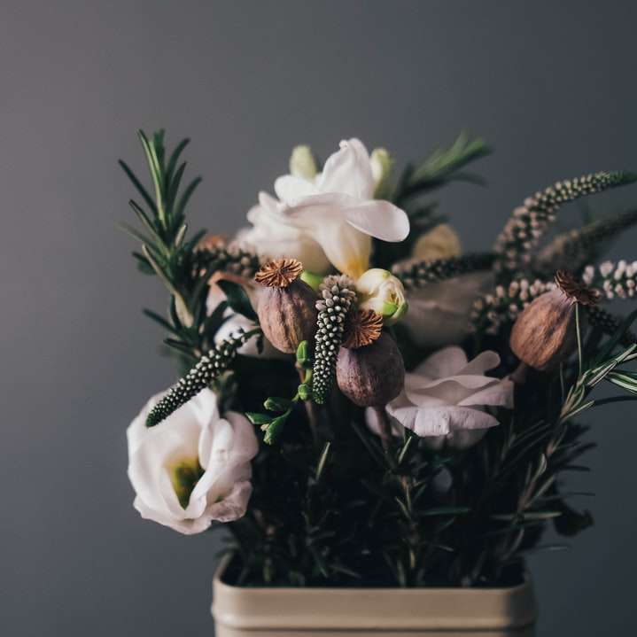 vita kronbladsblommor i grå kruka i rummet Pussel online