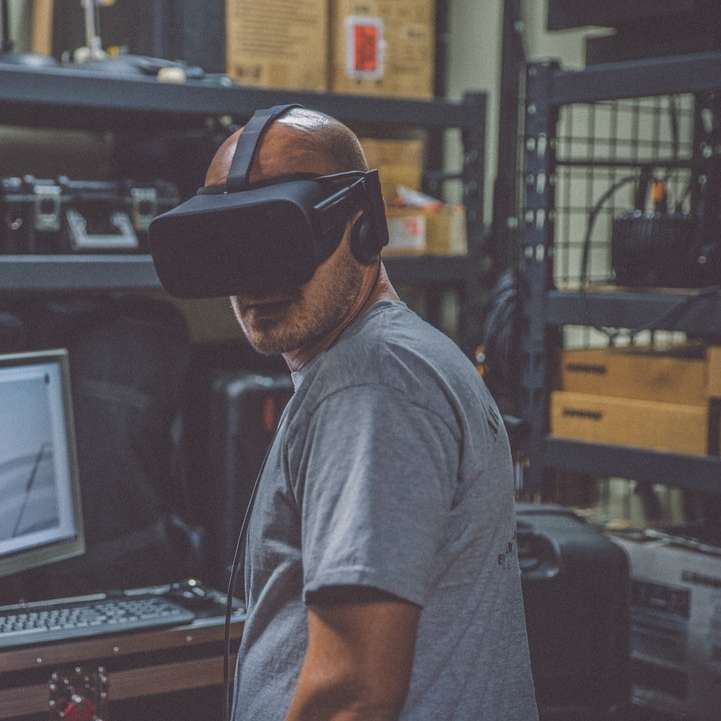 людина, яка використовує чорну гарнітуру VR перед комп'ютером розсувний пазл онлайн