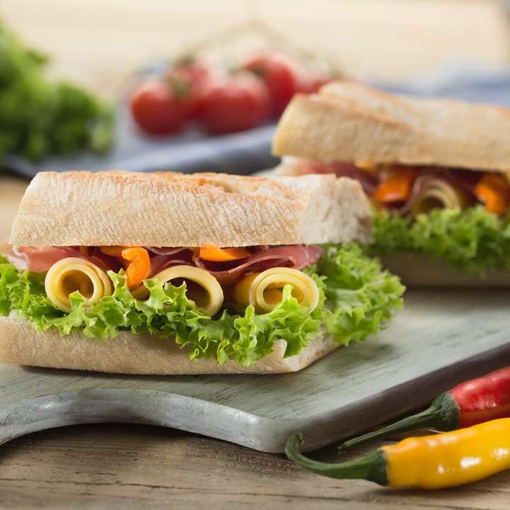 Sandwich mit Salat und Käse auf einem Schneidebrett serviert Schiebepuzzle online