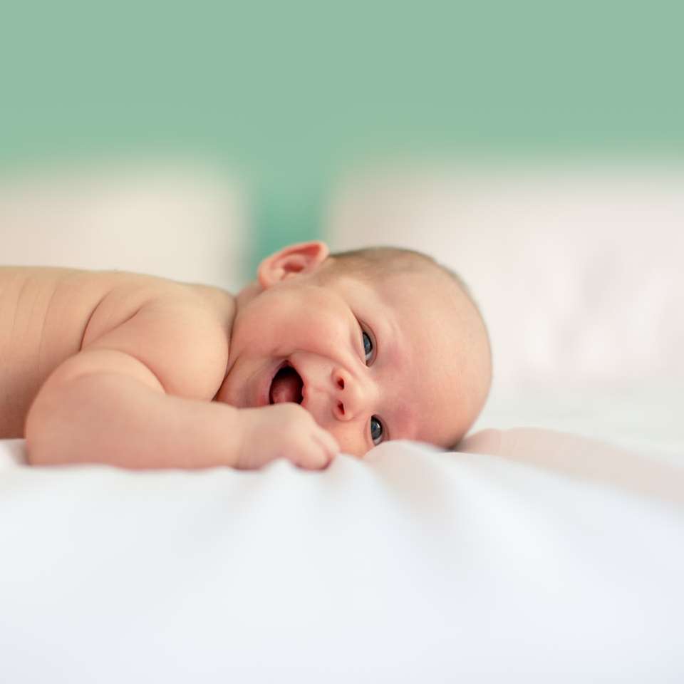 baby lying on fabric cloth sliding puzzle online