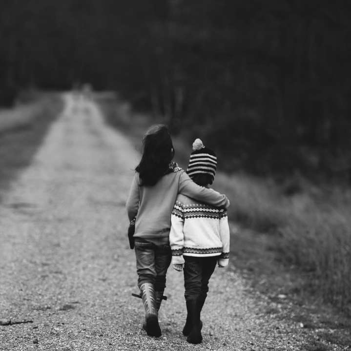 Fotografía en escala de grises de niños caminando en la carretera. rompecabezas en línea