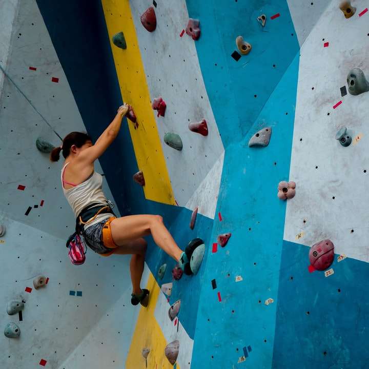 person in white tank top rock climbing sliding puzzle online