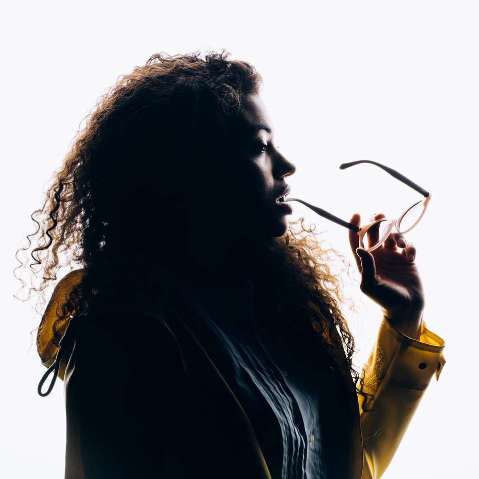 силуетна фотографія жінки, яка кусає окуляри онлайн пазл