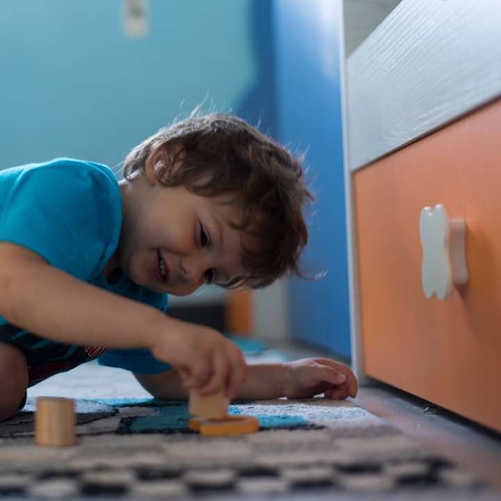 niña en camiseta azul jugando con juego de mesa de madera marrón puzzle deslizante online