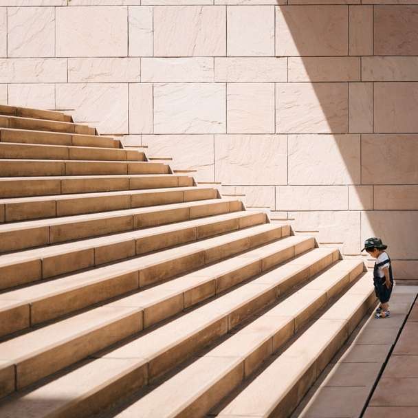 maluch stoi przed beżowymi betonowymi schodami puzzle przesuwne online