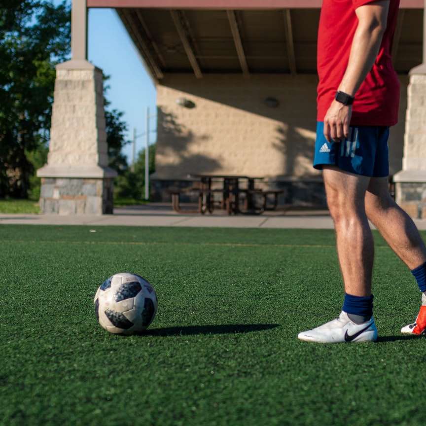 mężczyzna w czerwonej koszuli i niebieskich spodenkach gra w piłkę nożną puzzle przesuwne online