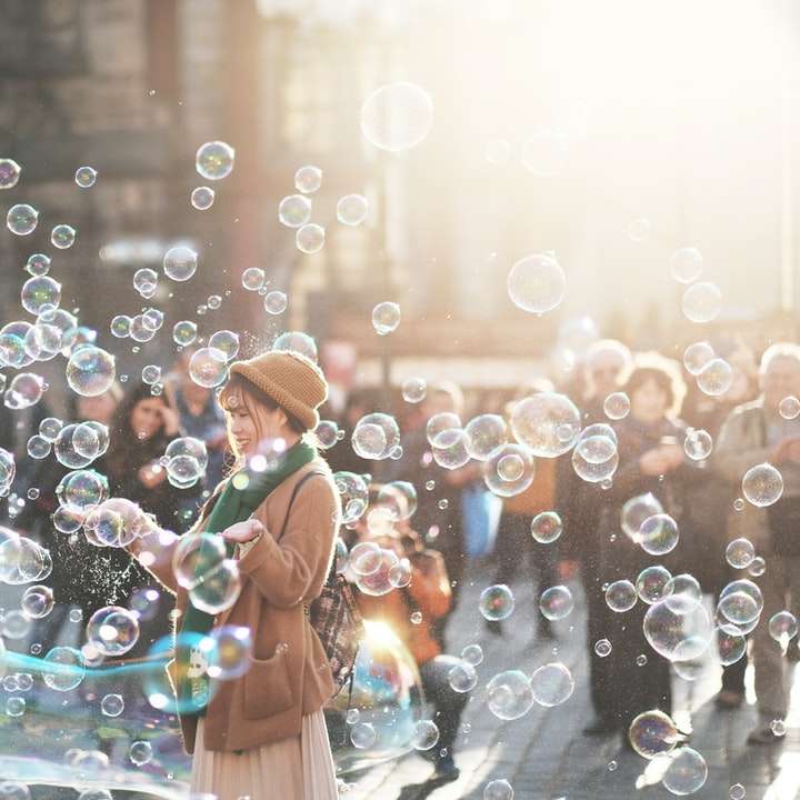 kvinna som står utomhus omgiven av bubblor under dagtid Pussel online