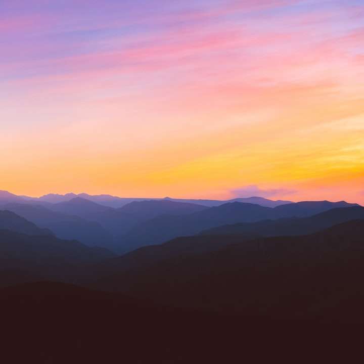 Silhouettenfoto des Berges während der goldenen Stunde Schiebepuzzle online