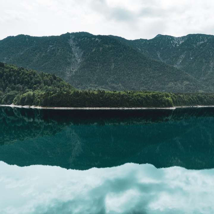 calmo specchio d'acqua vicino alla montagna puzzle online