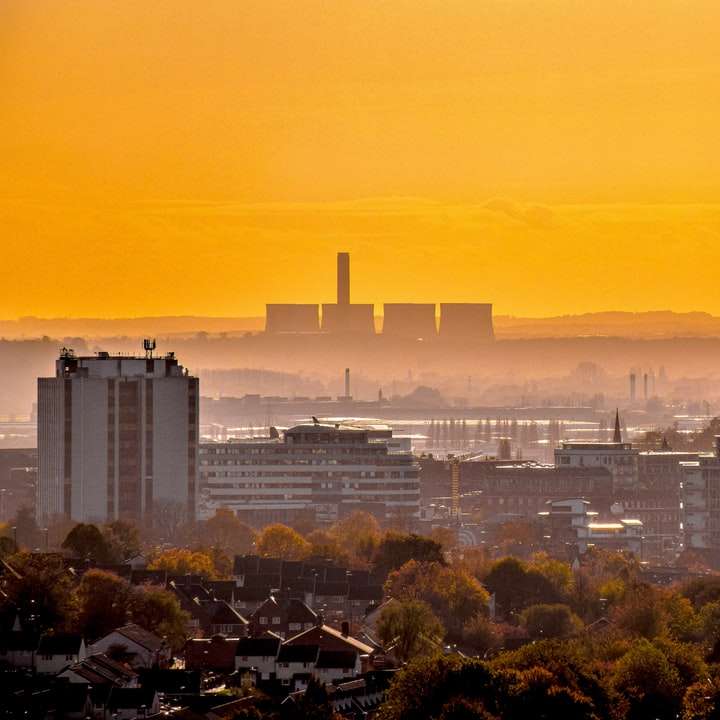 Skyline der Stadt während des orangefarbenen Sonnenuntergangs Schiebepuzzle online