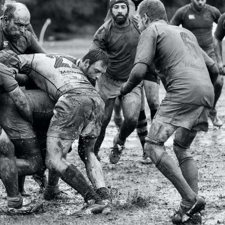 grijswaardenfotografie van een groep mensen die rugby spelen schuifpuzzel online
