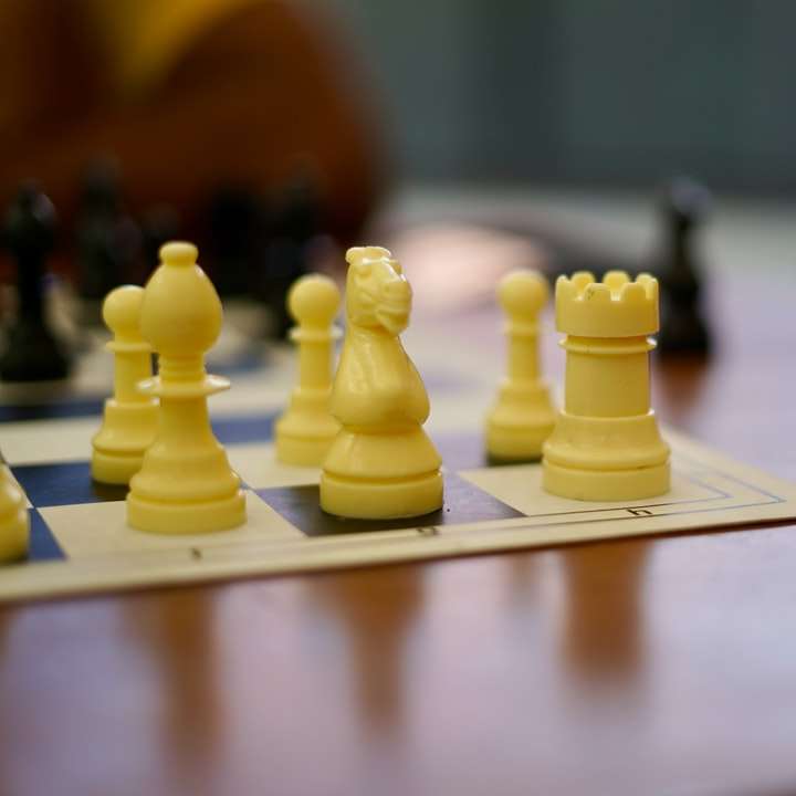 gul plast schackpjäs på vitt bord glidande pussel online