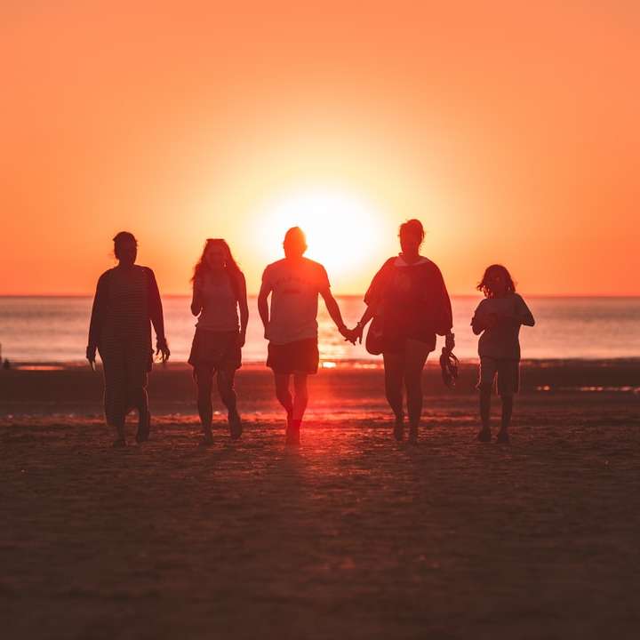 silhouetfoto van vijf personen die aan de kust lopen online puzzel