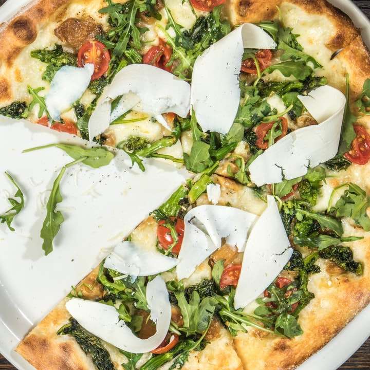 több szeletelt zöldség pizza kerek fehér tálon online puzzle