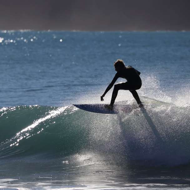 person som rider surfbräda på vattenfat glidande pussel online