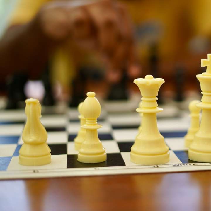 Pieza de ajedrez amarillo sobre estante de madera marrón rompecabezas en línea