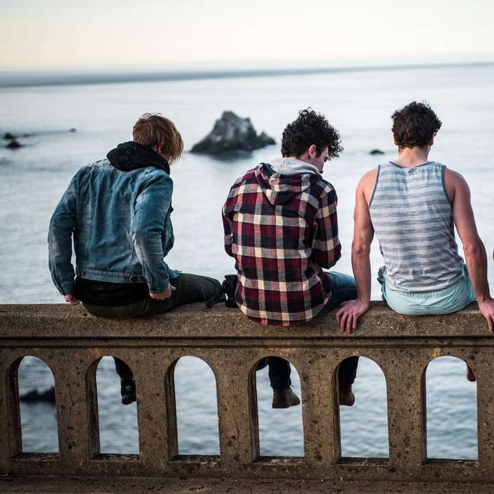 чотири людини сидять на лавці перед водоймою онлайн пазл