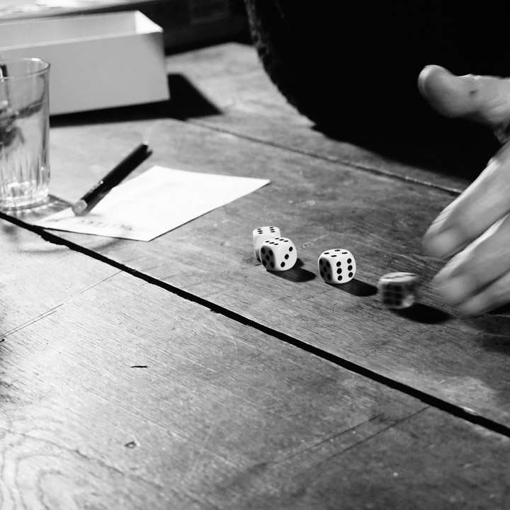 photo en niveaux de gris d'une personne tenant une pièce d'échecs puzzle coulissant en ligne