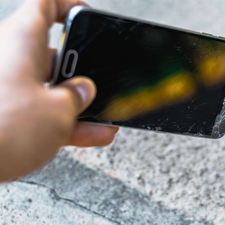 Personne tenant un smartphone android samsung noir puzzle coulissant en ligne