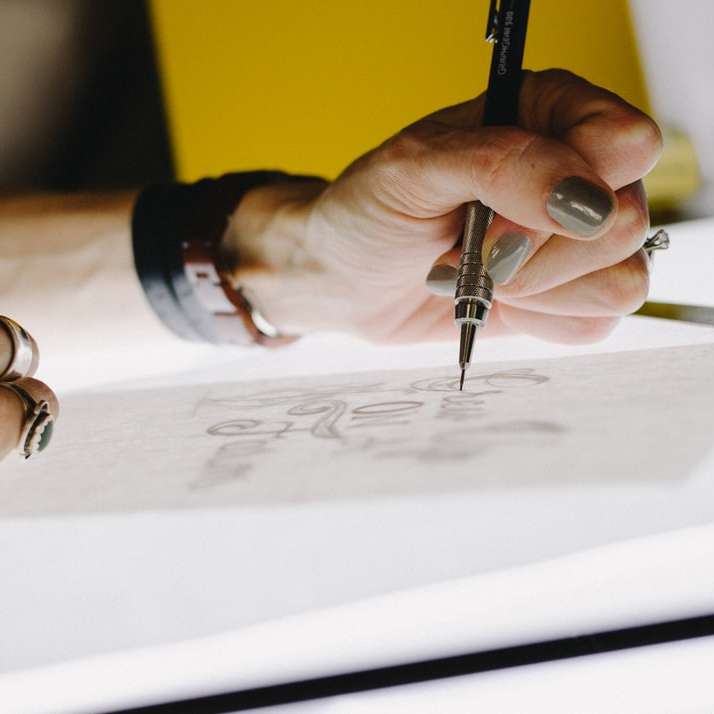 Человек делает надпись на кальке с помощью механического карандаша онлайн-пазл